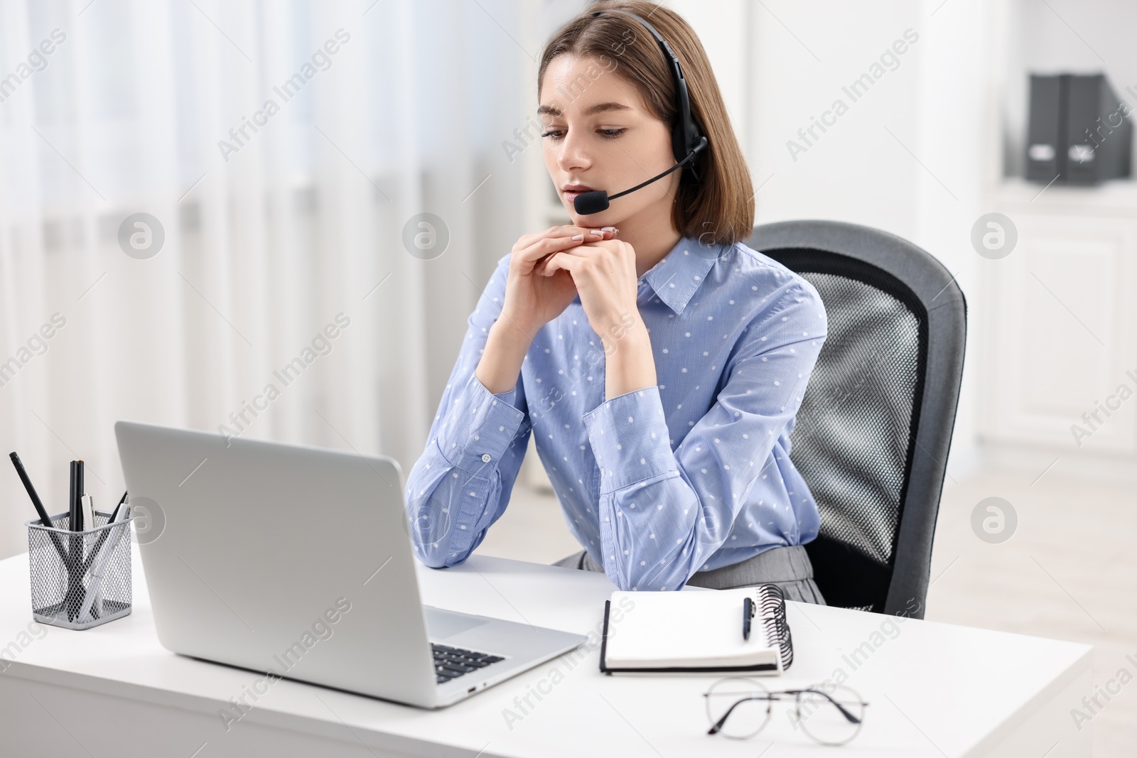 Photo of Teenager in headset having video chat via laptop at home. Remote work