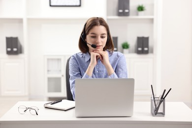 Teenager in headset having video chat via laptop at home. Remote work