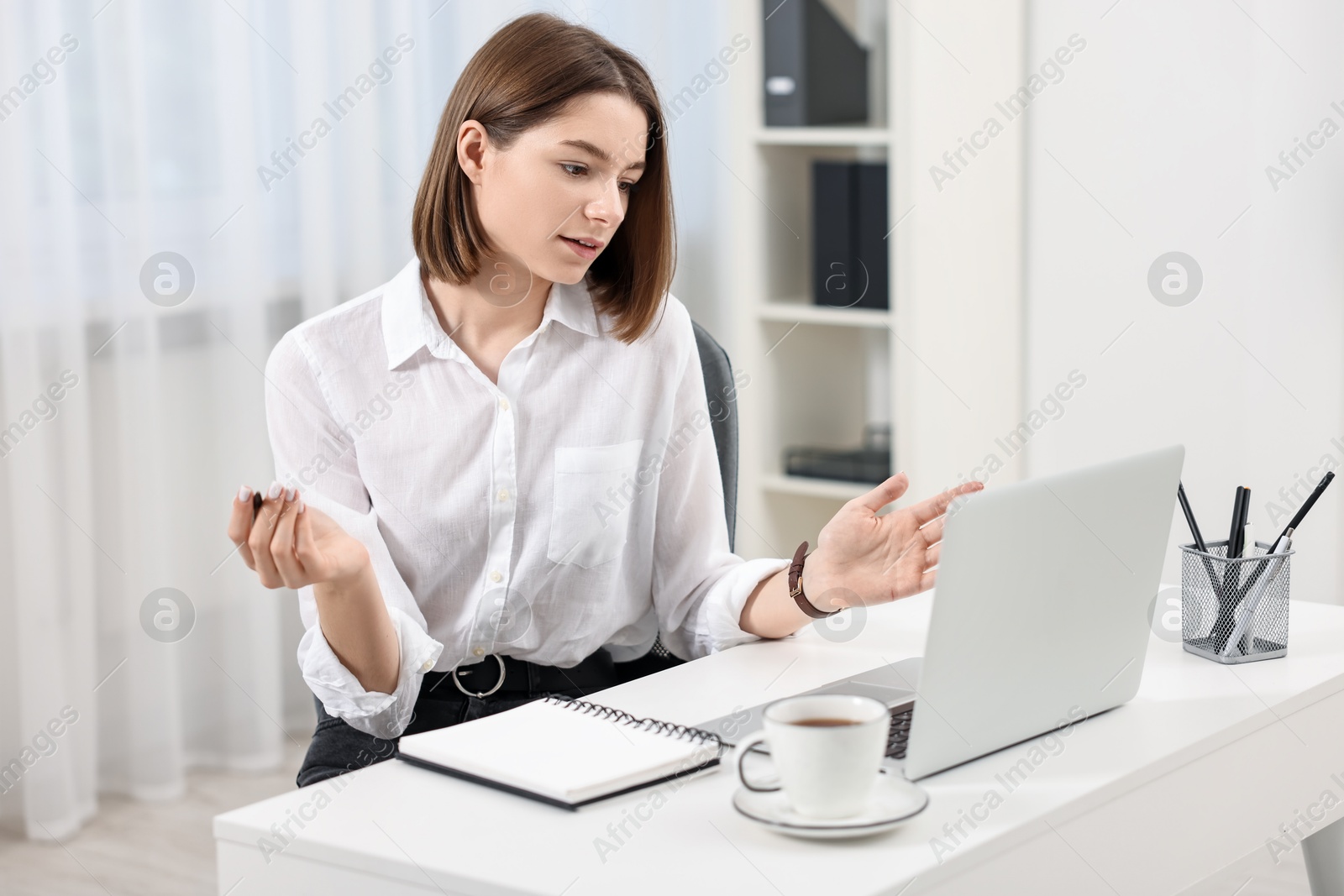 Photo of Teenager having video chat via laptop at home. Remote work