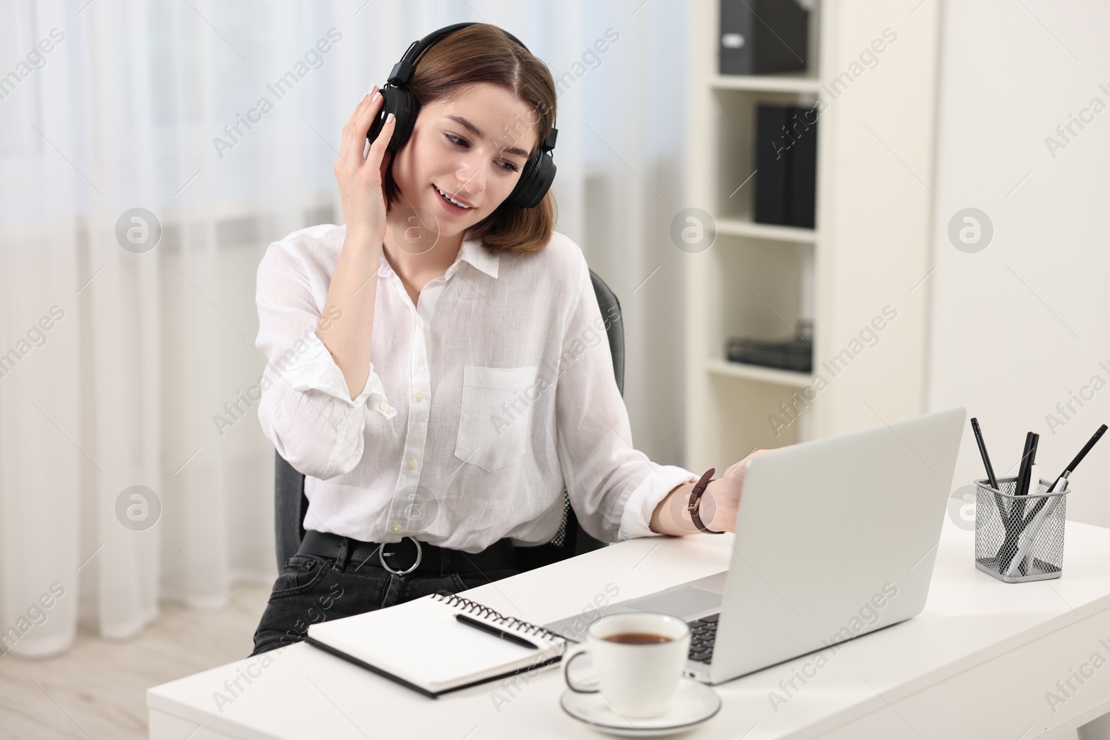 Photo of Teenager in headset having video chat via laptop at home. Remote work