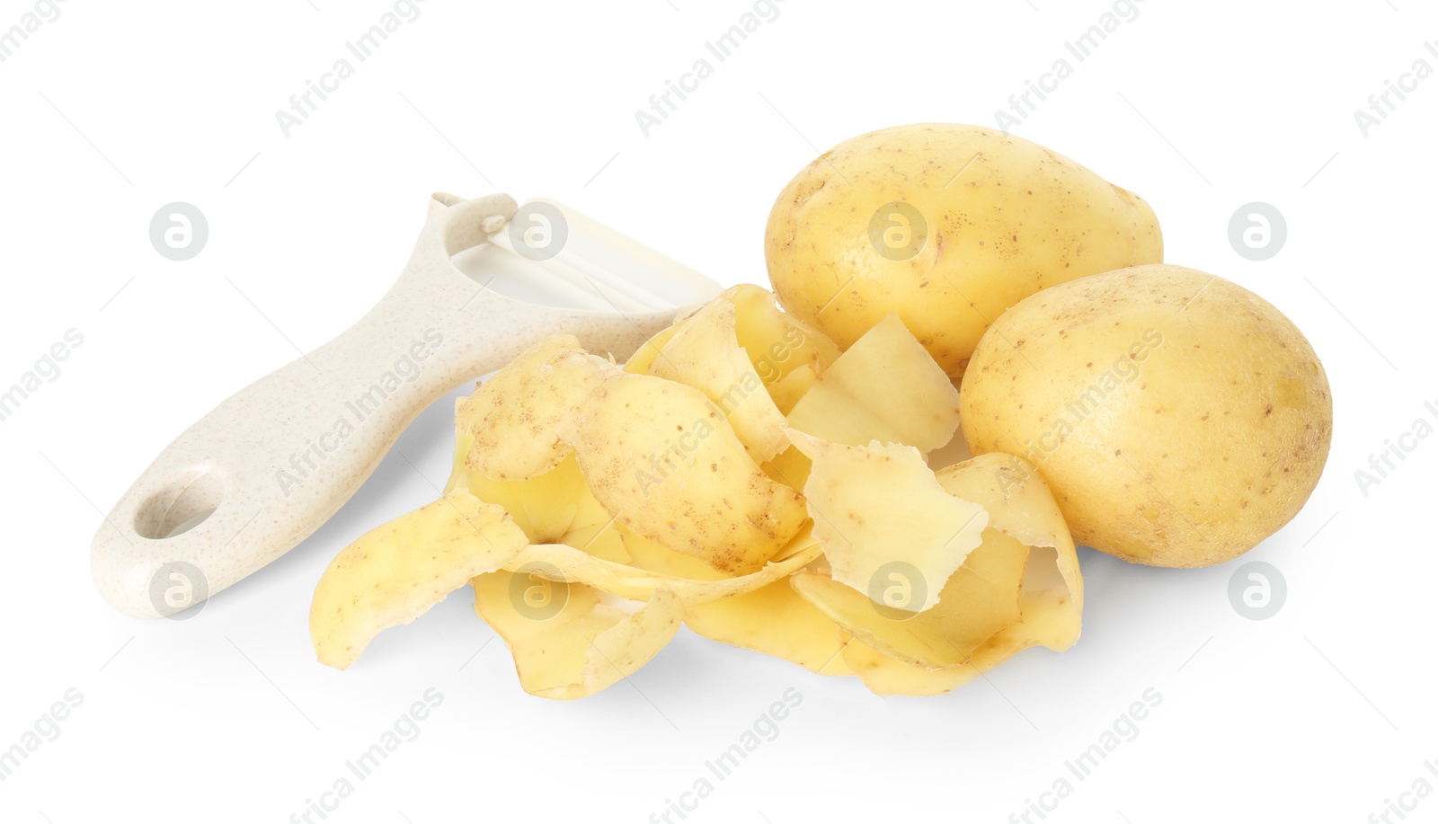 Photo of Young potatoes, peels and peeler isolated on white