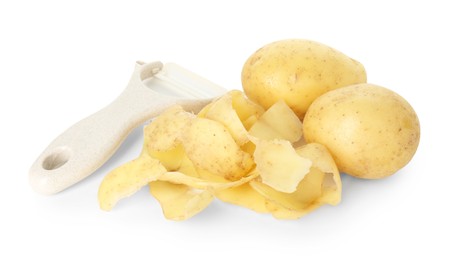 Photo of Young potatoes, peels and peeler isolated on white