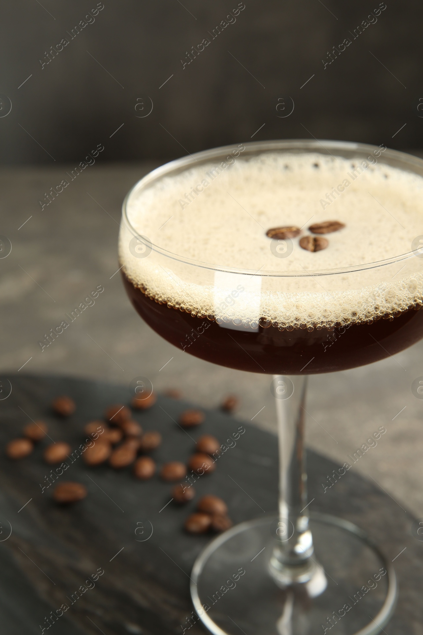 Photo of Espresso Martini cocktail in glass on grey table, closeup