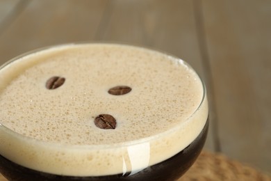 Photo of Glass of fresh coffee cocktail on light table, closeup