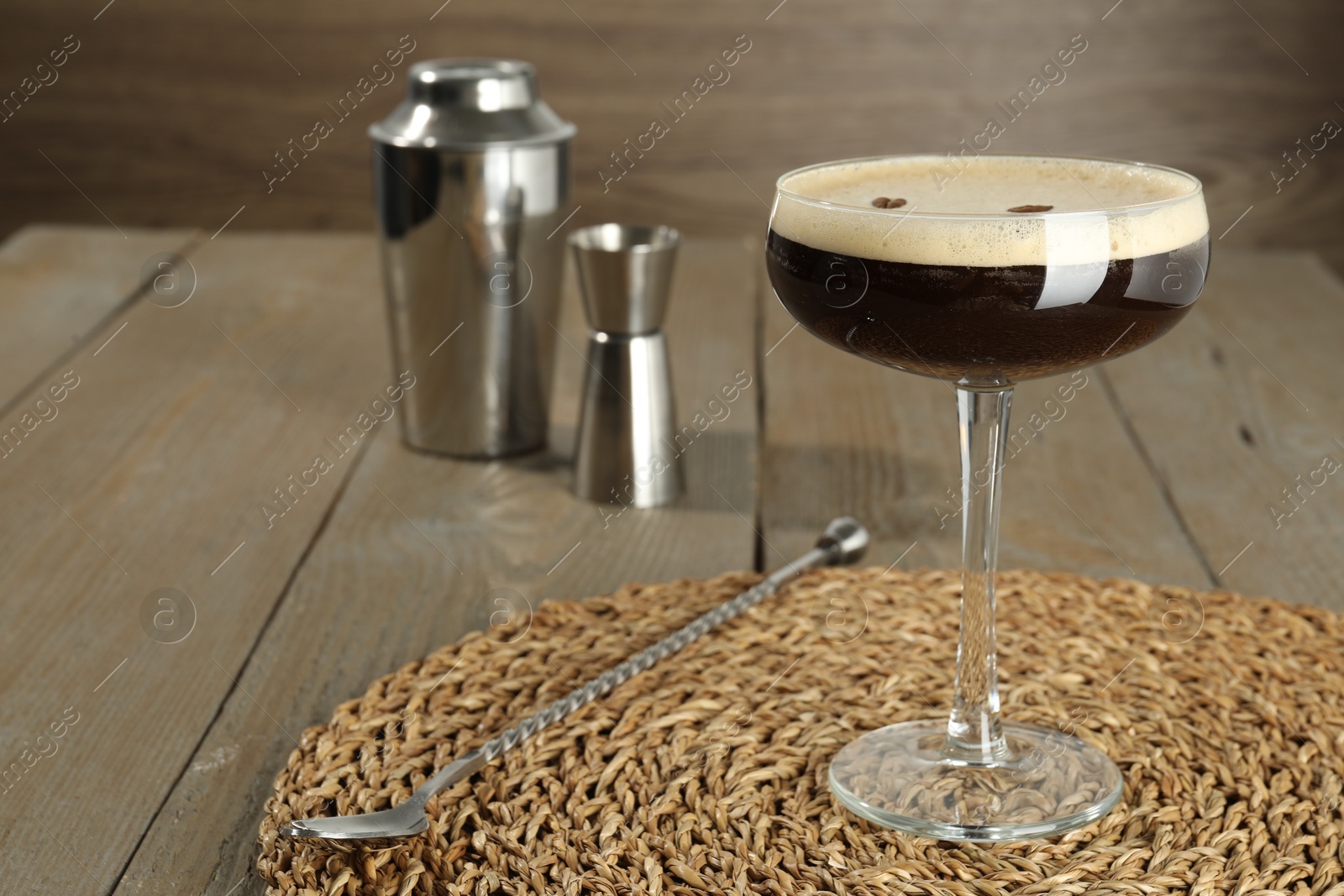 Photo of Glass of fresh coffee cocktail and bartender equipment on wooden table