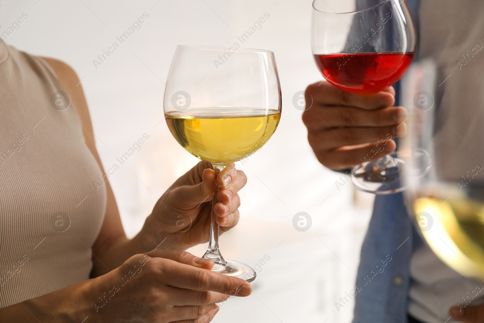 Photo of Friends with glasses of wine indoors, selective focus