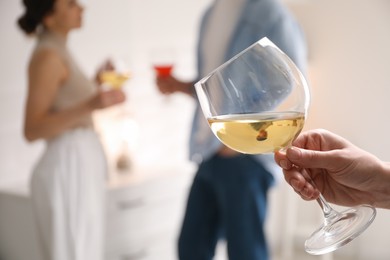 Woman with glass of wine indoors, selective focus