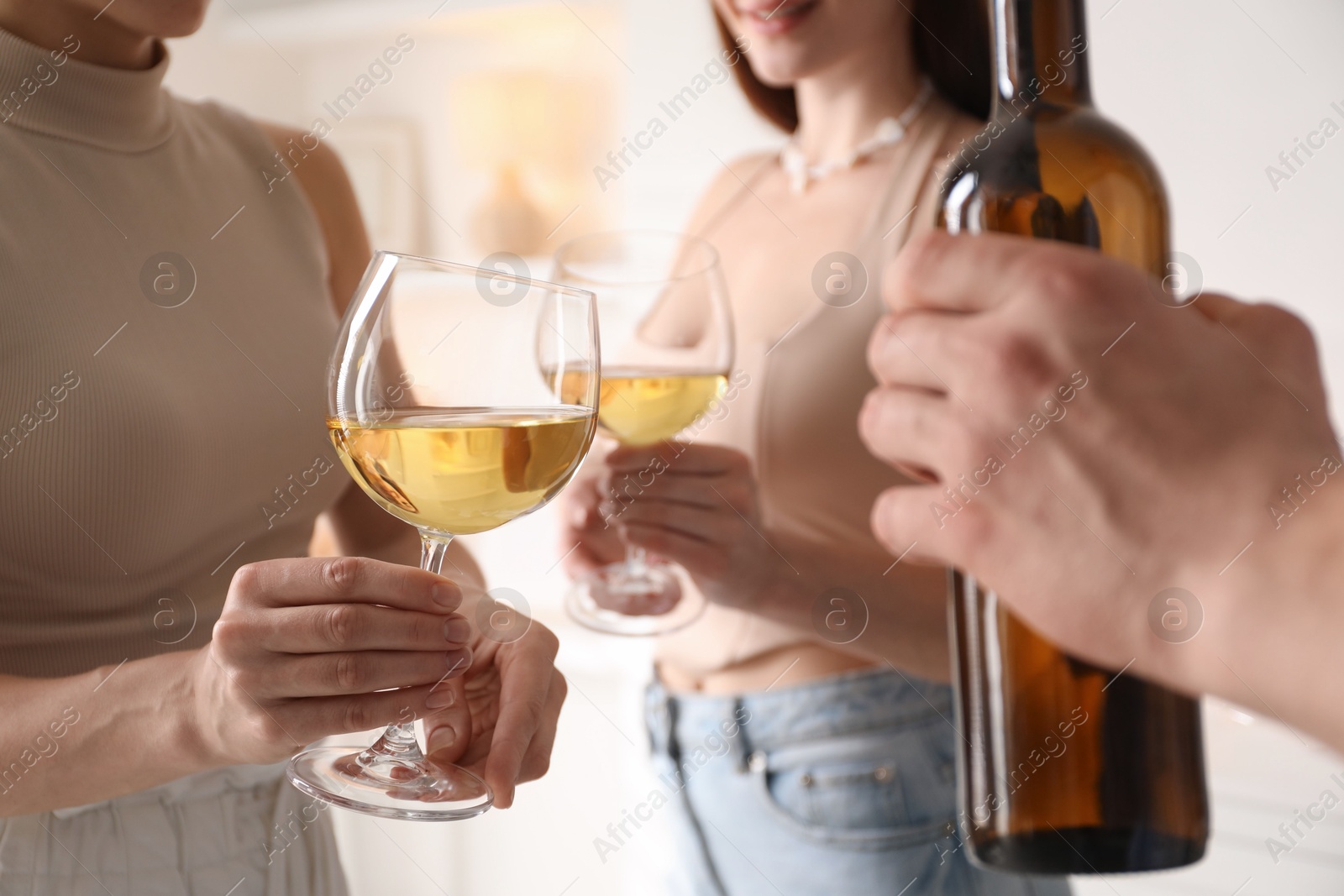 Photo of Friends with glasses of wine indoors, selective focus