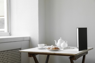 Photo of Croissants, tea and light reflector on table in studio. Professional food photography