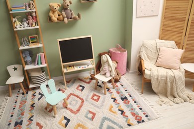 Stylish child room interior with different toys and furniture