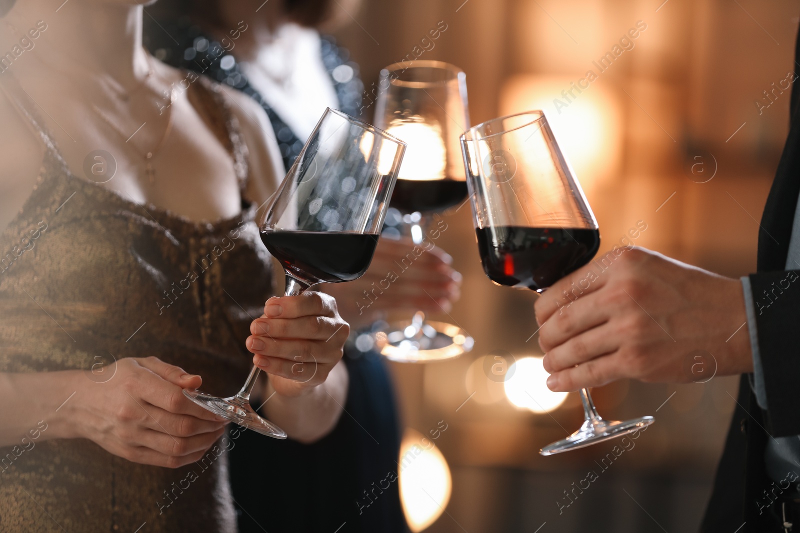 Photo of Women and man clinking glasses of tasty wine at party, closeup