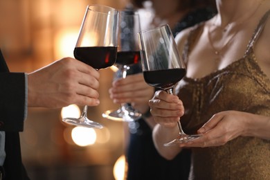 Women and man clinking glasses of tasty wine at party, closeup