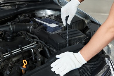 Photo of Auto mechanic fixing car at automobile repair shop, closeup