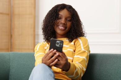 Photo of Beautiful woman using mobile phone at home