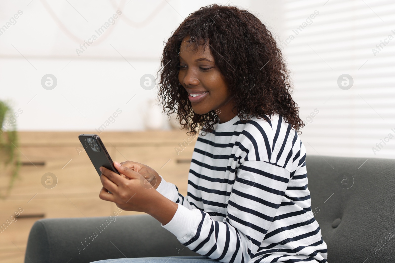 Photo of Beautiful woman using mobile phone at home