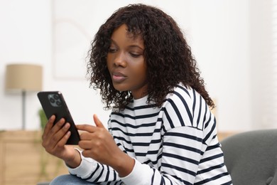 Photo of Beautiful woman using mobile phone at home