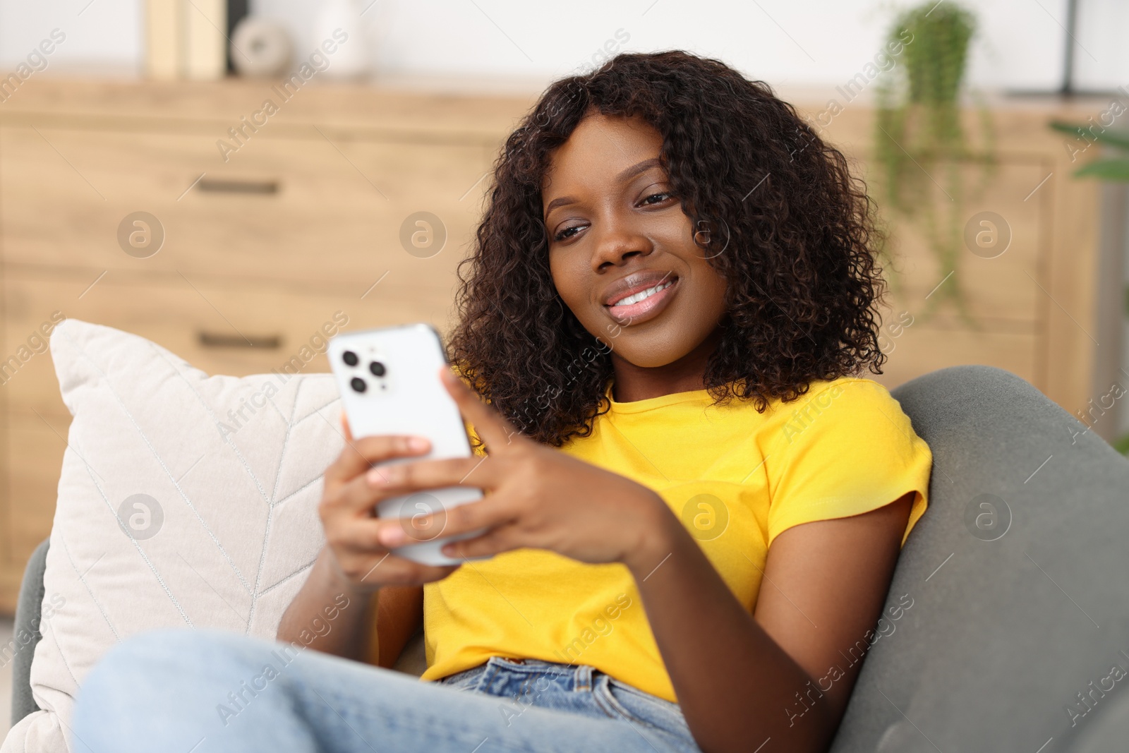 Photo of Beautiful woman using mobile phone at home