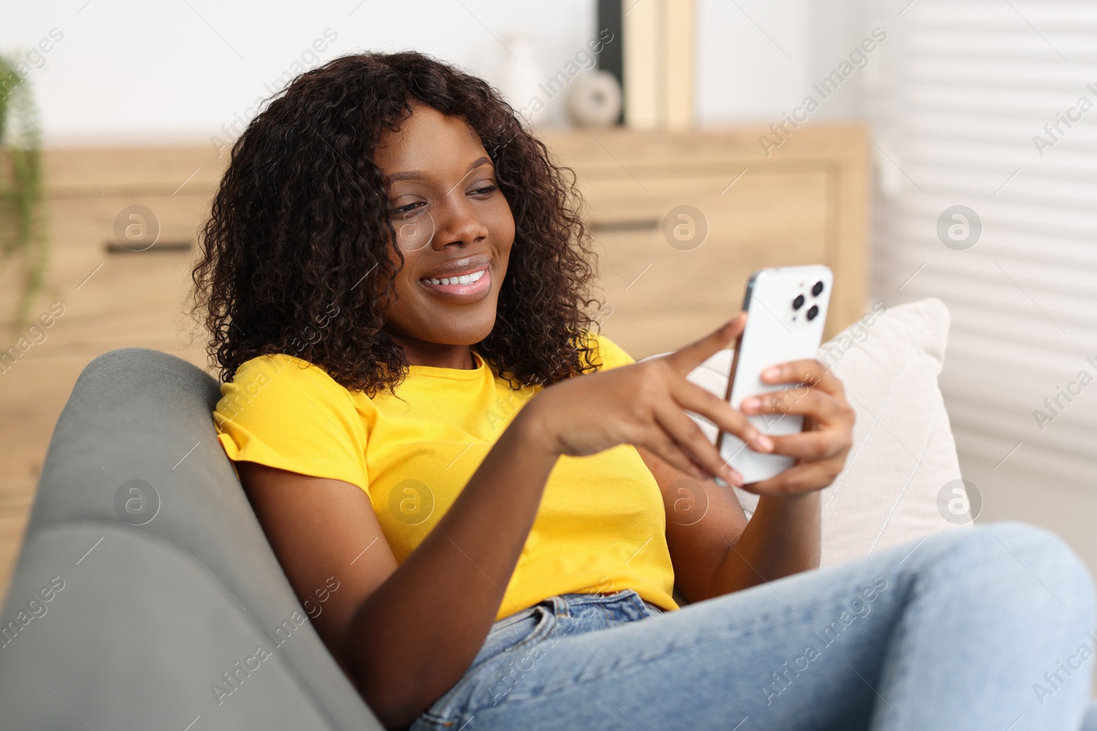 Photo of Beautiful woman using mobile phone at home