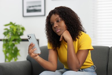 Photo of Beautiful woman using mobile phone at home