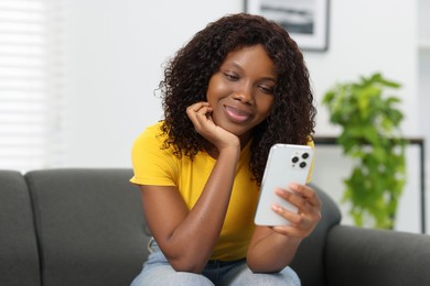 Photo of Beautiful woman using mobile phone at home