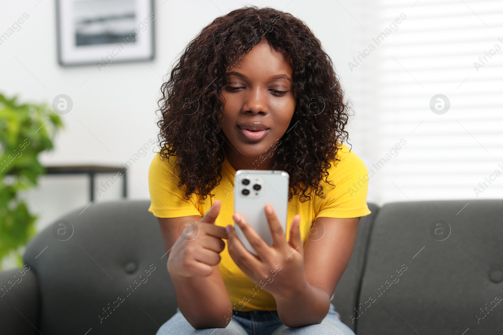 Photo of Beautiful woman using mobile phone at home