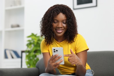 Photo of Beautiful woman using mobile phone at home