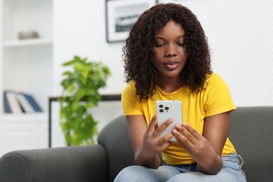 Photo of Beautiful woman using mobile phone at home