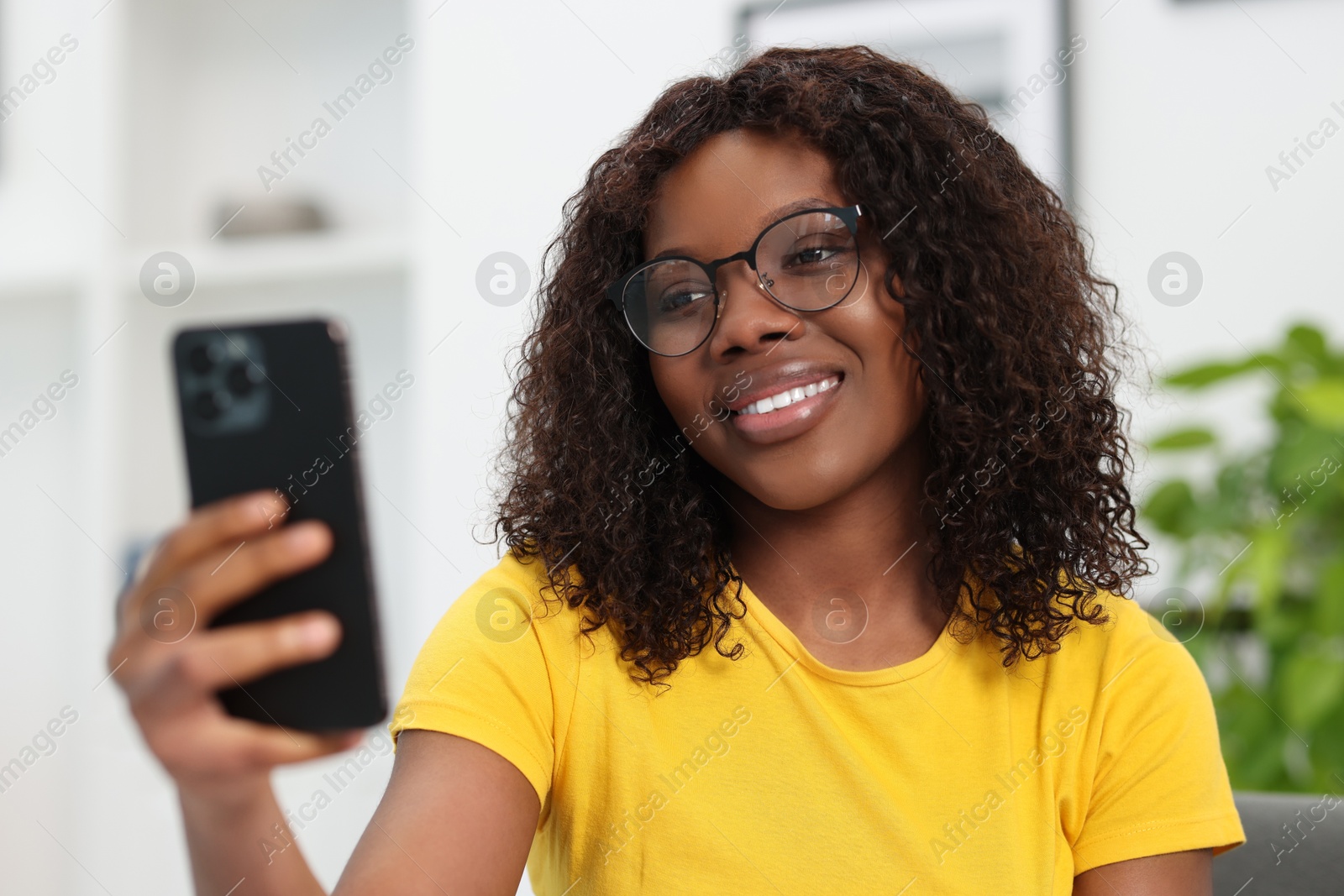 Photo of Beautiful woman using mobile phone at home