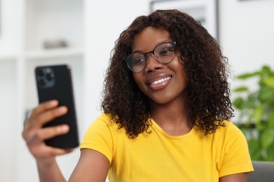 Photo of Beautiful woman using mobile phone at home