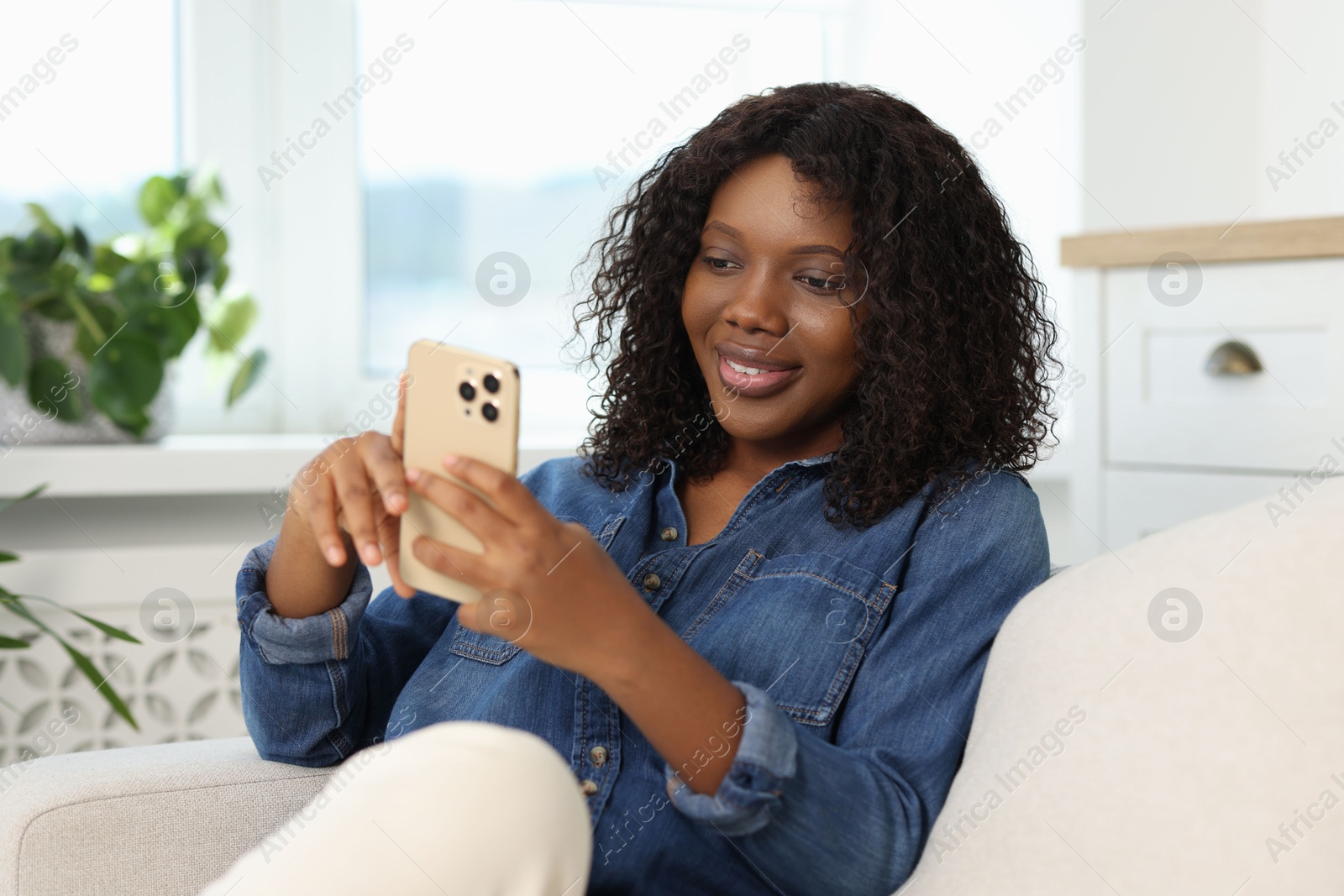 Photo of Beautiful woman using mobile phone at home