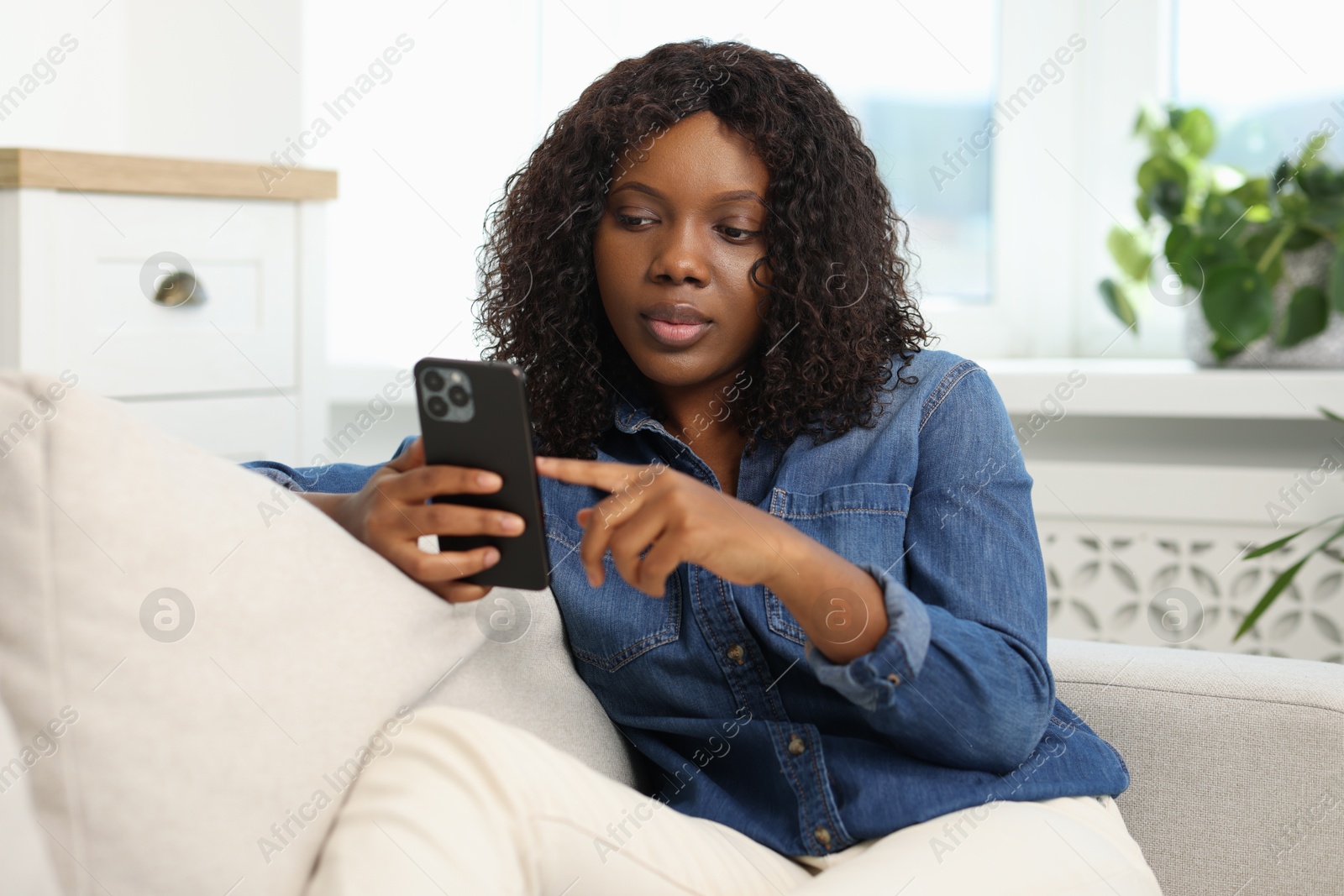 Photo of Beautiful woman using mobile phone at home