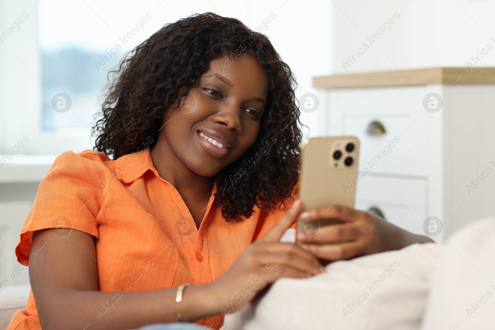 Photo of Beautiful woman using mobile phone at home