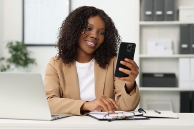 Beautiful woman using mobile phone in office