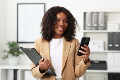 Photo of Beautiful woman using mobile phone in office