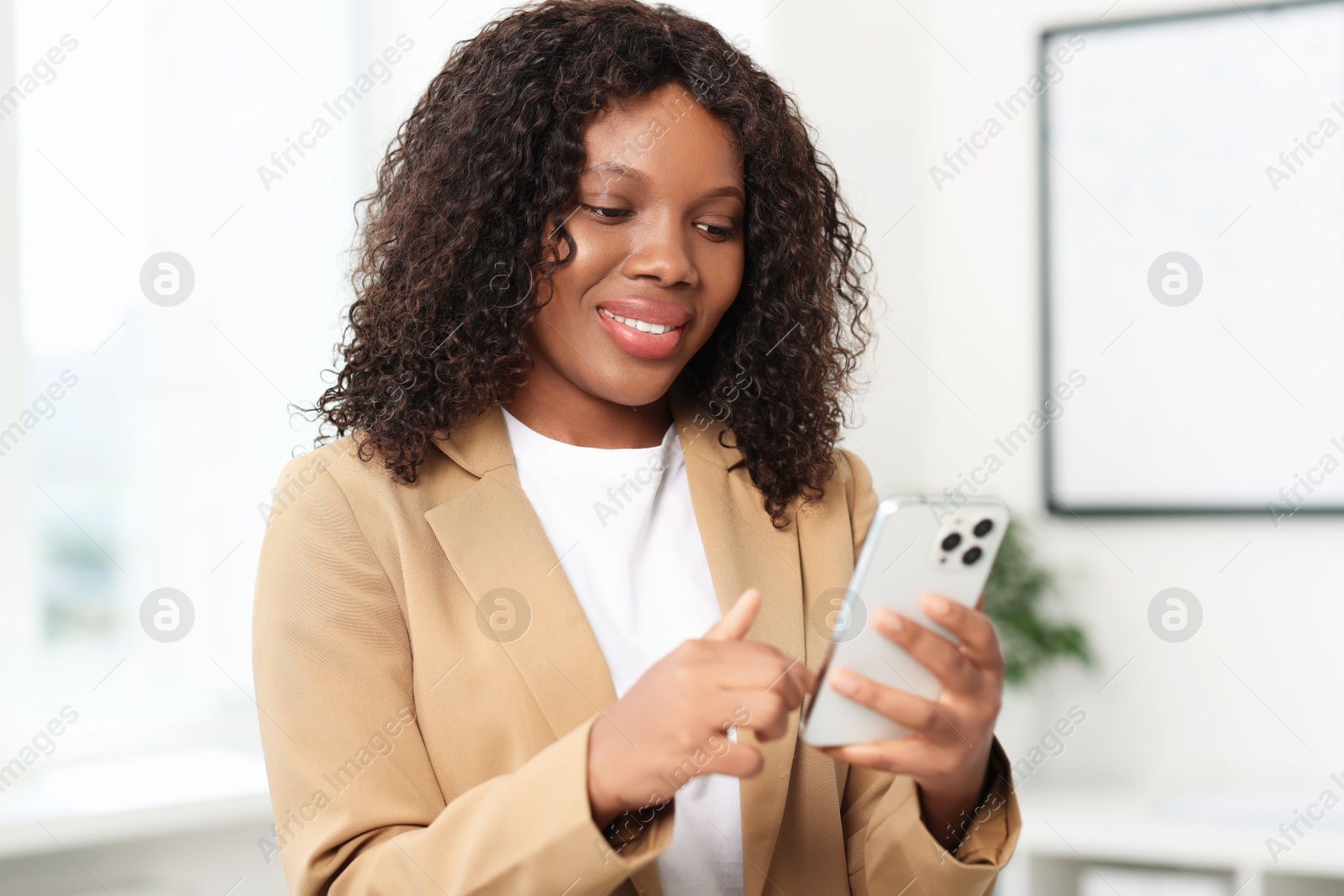 Photo of Beautiful woman using mobile phone in office