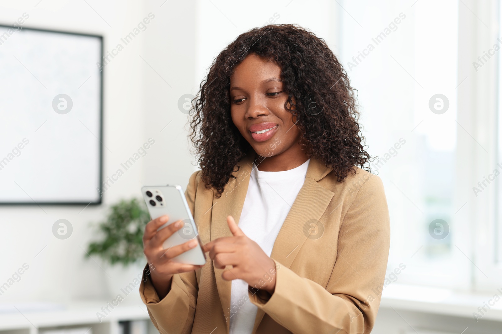 Photo of Beautiful woman using mobile phone in office