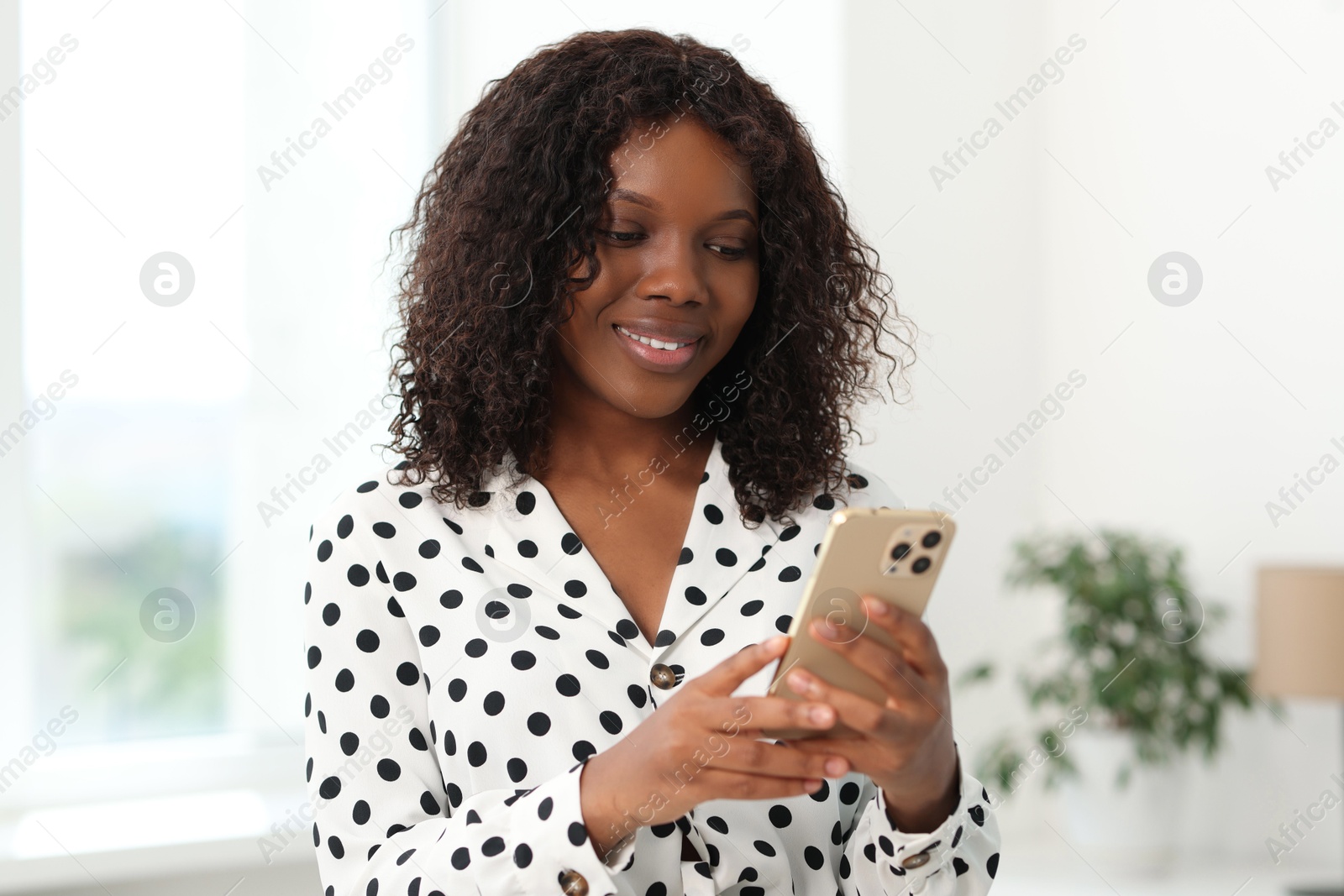 Photo of Beautiful woman using mobile phone at home