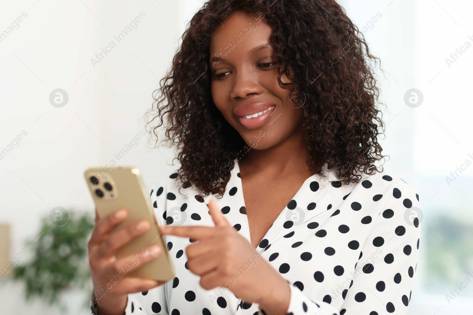 Photo of Beautiful woman using mobile phone at home