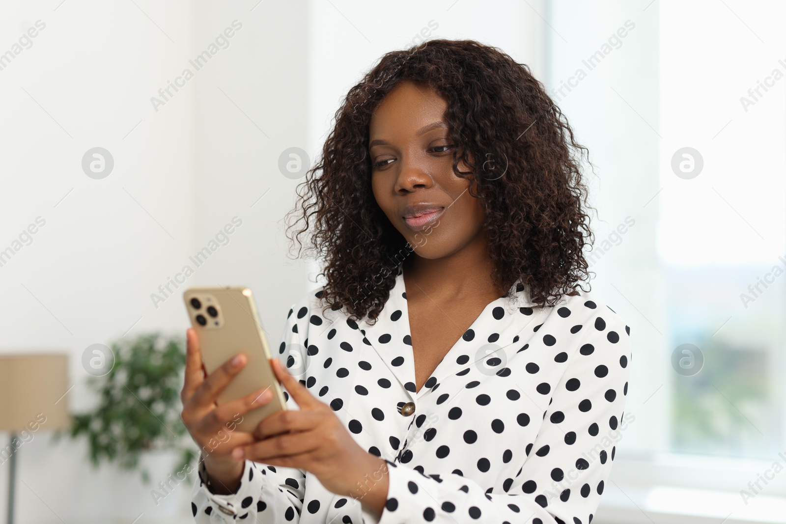 Photo of Beautiful woman using mobile phone at home