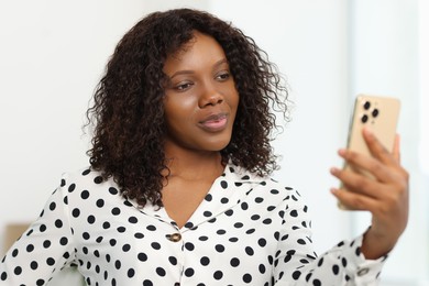 Photo of Beautiful woman using mobile phone at home