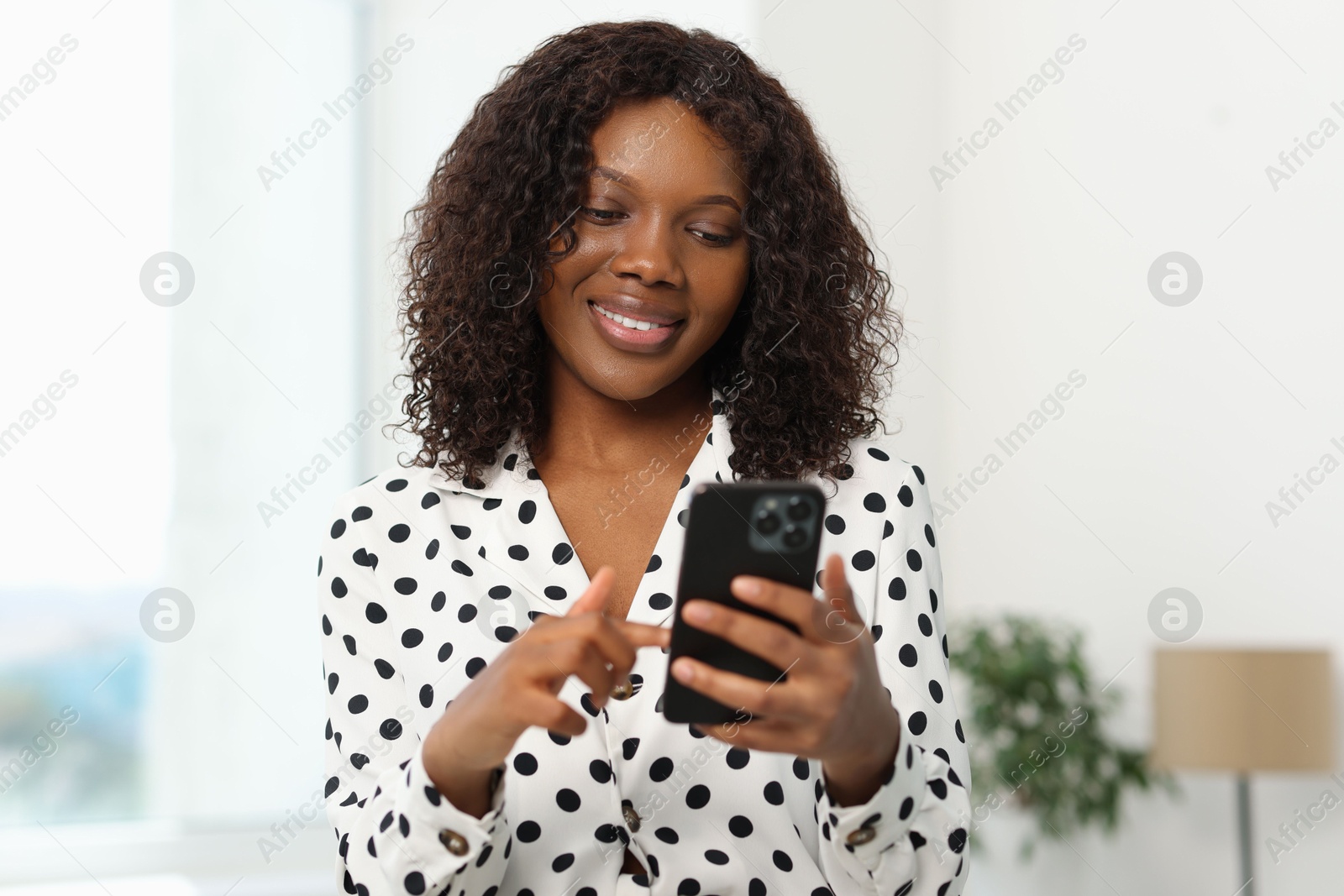 Photo of Beautiful woman using mobile phone at home