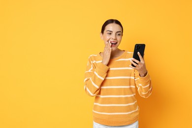 Photo of Happy woman with smartphone on yellow background. Space for text