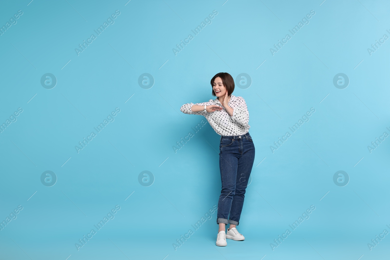 Photo of Happy woman on light blue background. Space for text