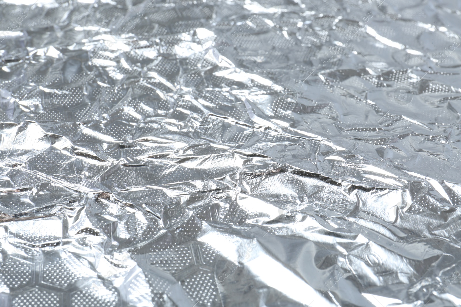 Photo of Shiny silver tinfoil surface as background, closeup