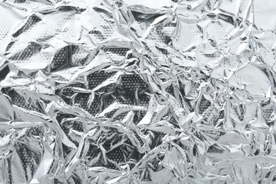 Shiny silver tinfoil surface as background, top view