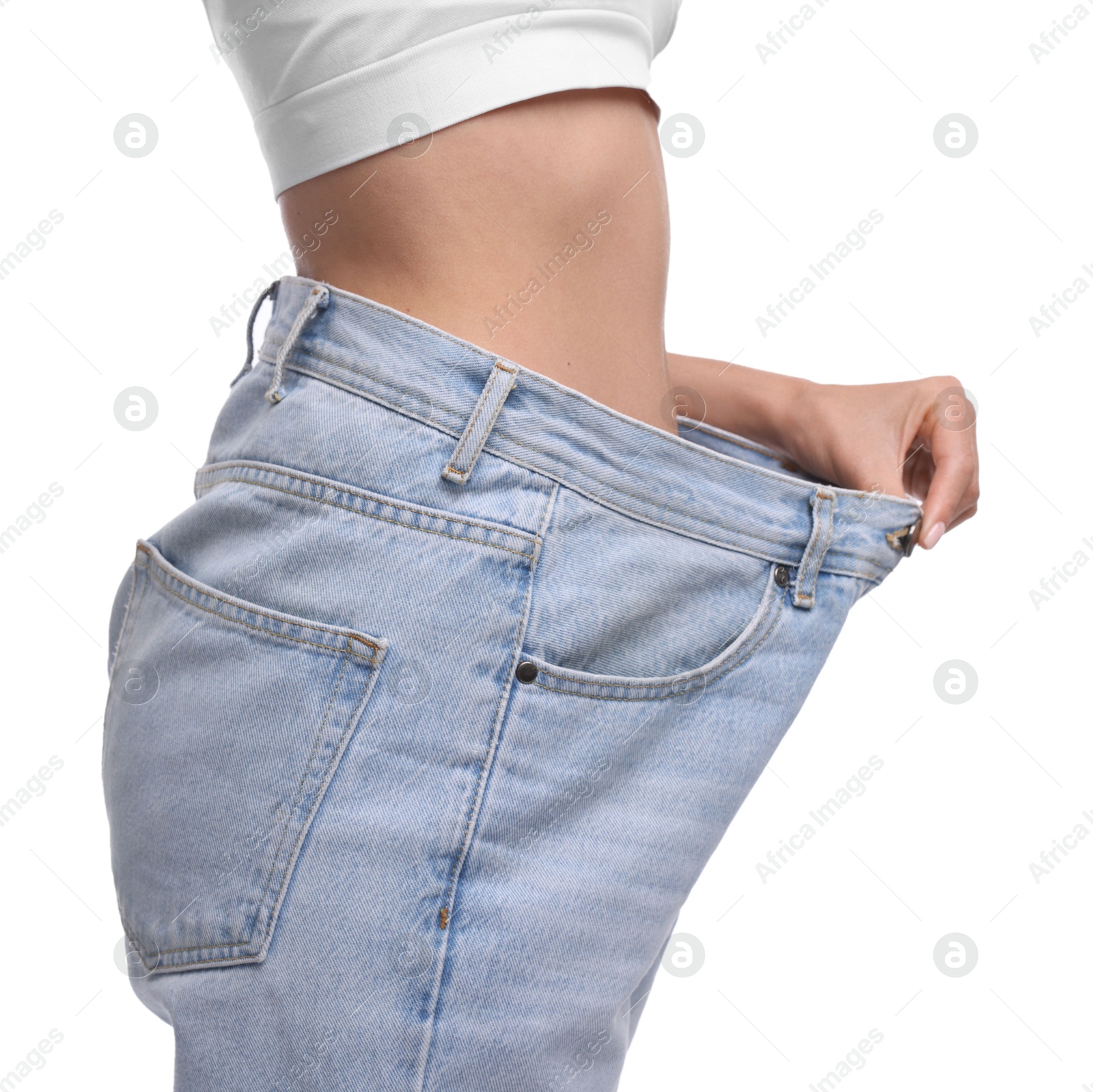 Photo of Diet and weight loss concept. Woman in big jeans showing her slim body on white background, closeup