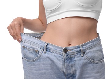 Photo of Diet and weight loss concept. Woman in big jeans showing her slim body on white background, closeup