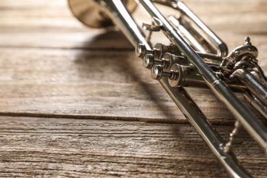 One trumpet on wooden table, closeup. Space for text