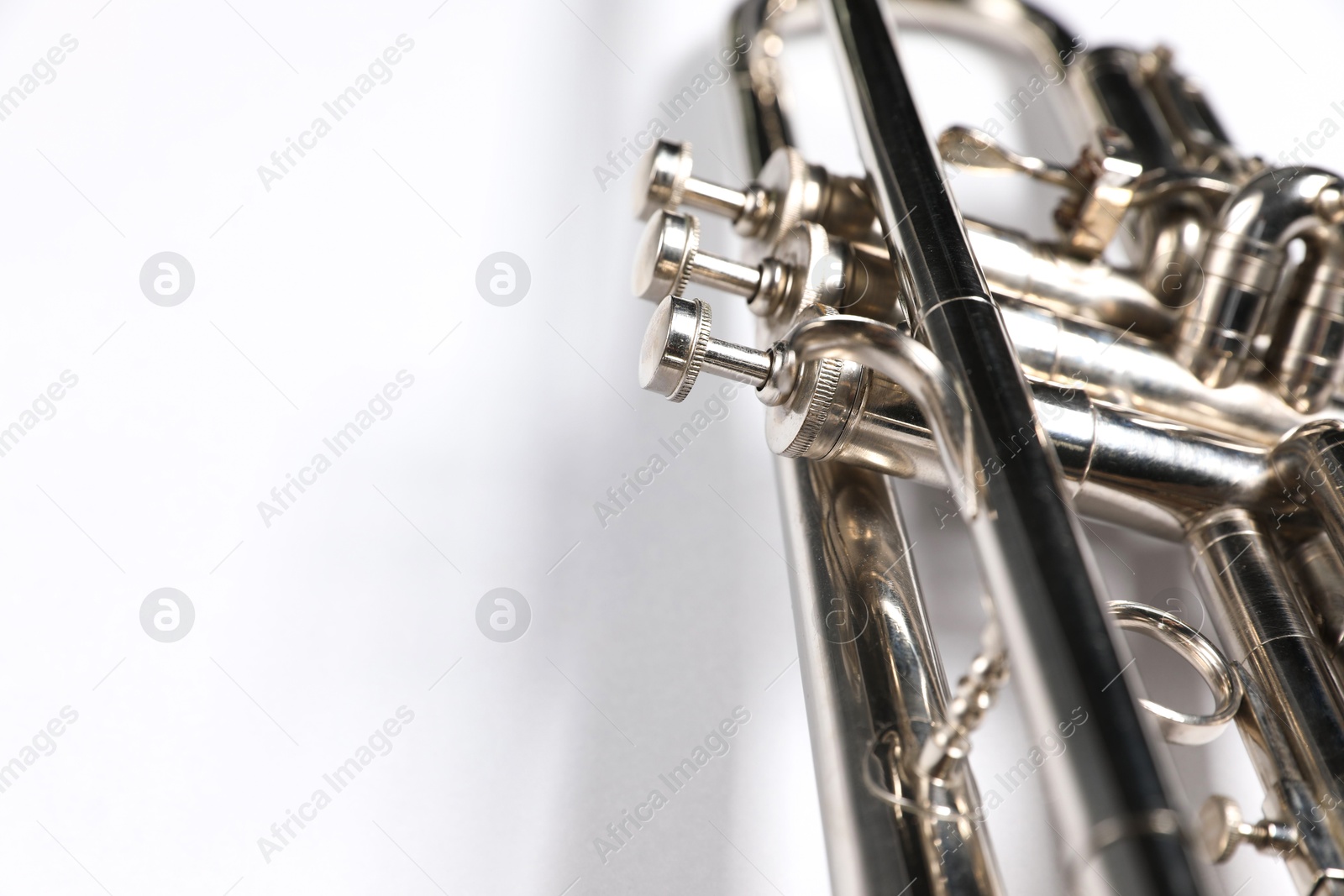 Photo of One trumpet on light background, closeup. Space for text