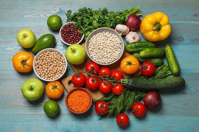 Photo of Different vegetarian products on light blue wooden table, top view